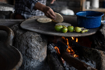 Mexican woman making a corn tortillas in a traditional way