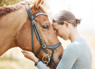 He moves as if he always hears music. an attractive young woman standing with her horse in a forest.