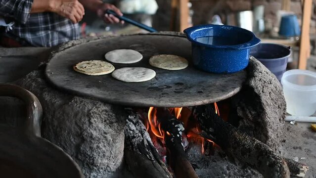 Mexican woman making a corn tortillas in a traditional way
