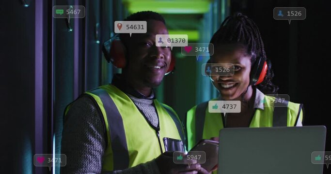 Animation of social media icons over african american male and female engineers at server room