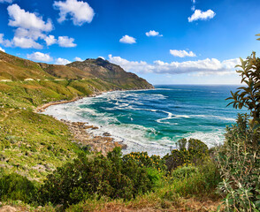 Obraz premium A photo of mountains, coast and ocean from Shapmanns Peak,. A photo mountains, coast and ocean from Shapmanns Peak, with Hout Bay in the background. Close to Cape Town.
