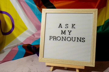 ASK MY PRONOUNS text Neo pronouns concept on Rainbow flag background gender pronouns. Non-binary...