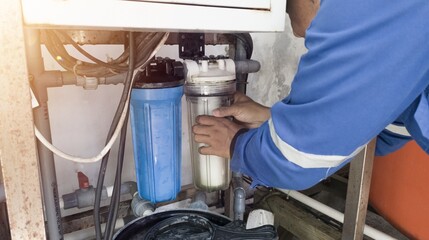 a man is changing the clean water filter, the process of changing the water treatment machine filter.