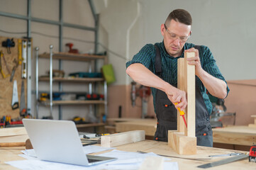 Caucasian man assembling a table with a screwdriver. 
