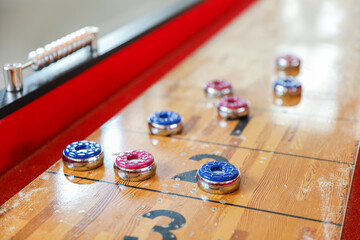 Shuffleboard is a game of precision and strategy, where players slide weighted discs down a narrow...
