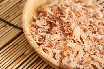 dry bonito fish flake katsuobushi in wood dish on bamboo rug table background. food dry bonito fish flake katsuobushi in wood dish on bamboo rug table background. dry bonito fish flake katsuobushi 