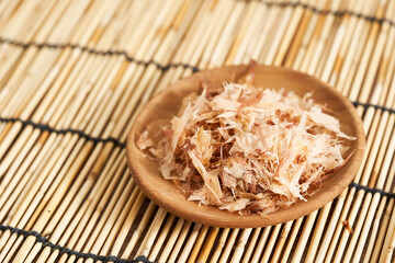 dry bonito fish flake katsuobushi in wood dish on bamboo rug table background. food dry bonito fish flake katsuobushi in wood dish on bamboo rug table background. dry bonito fish flake katsuobushi 