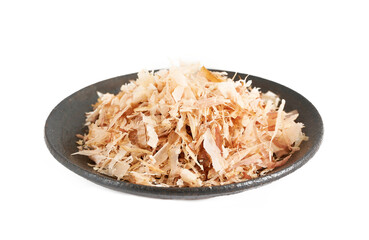 a pile of dry bonito fish flake katsuobushi in dish isolated on white background. heap of dry bonito fish flake katsuobushi isolated. bonito fish flake katsuobushi isolated                            