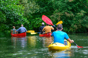 Wildromantische Flusslandschaft mit Kajak- und Kanufahrern