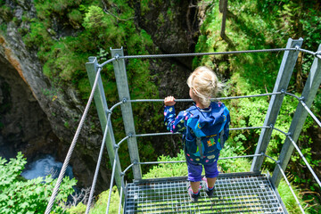 Kleines Mädchen blickt staunend in eine tiefe Schlucht in den Allgäuer Alpen