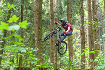 Mutiger Mountainbiker beim Jump über eine Rampe im Wald © ARochau