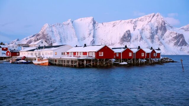 Spectacular winter view of popular tourist destination - Lofoten Islands archipelago. Red houses on the shore of Norwegian sea. Sunrise on Sakrisoy fishing village.  Full HD video (High Definition)..