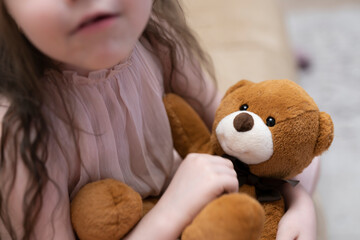 A girl, a brunette of seven years with a teddy bear in her hands. High quality photo