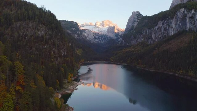 4k drone flight up footage (Ultra High Definition) of Gosausee (Vorderer) lake with Dachstein glacieron background. Attractive evening scene of Austrian Alps, Upper Austria, Europe.