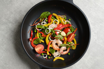 Overhead view of fresh vegetables and shrimps in a frying pan
