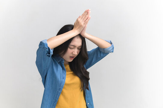 Portrait photo of funny Asian woman in colorful clothing posing begging, asking or making a wish on white background. People overacting posing gesture funny concept.