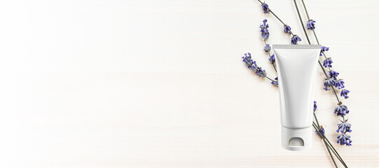 White empty bottle and dried lavender flowers on a white wooden background. The concept of natural, organic cosmetics. Banner, Flat lay, top view, copy space.