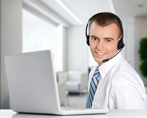 Technical support worker with a headset in modern office.