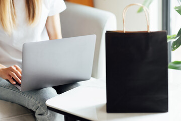 Creative promotion composition for Black friday with laptop and shopping bag on working desk. 