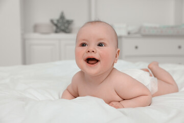 Cute baby lying on white bed at home