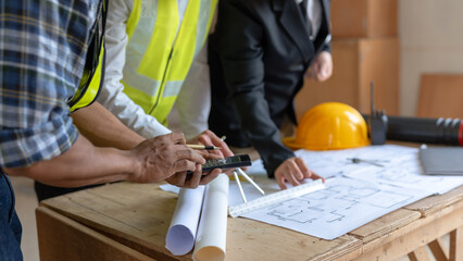 Architect or engineer are designing house, modifying plan, creating construction project and addition according to customer requirement.