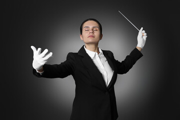 Professional conductor with baton on black background