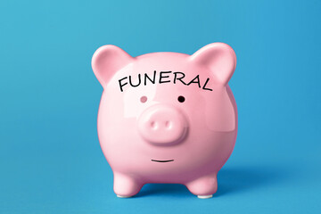 Money for funeral expenses. Pink piggy bank on light blue background