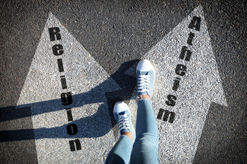 Philosophical or religious position. Woman standing on road marking arrow with word Atheism, closeup