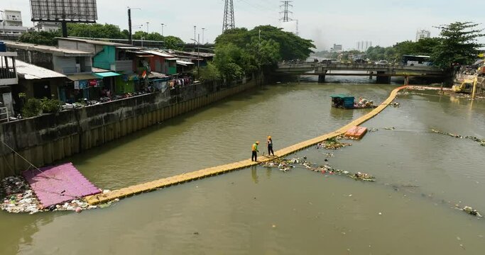 Floating rubbish trapper to stop debris on the Ciliwung river. Jakarta, Indonesia.