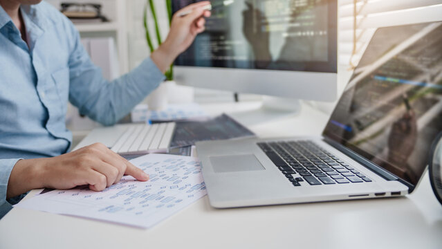 Programming developing software application. programmer writing program code with two monitors and working hacker on a new software
