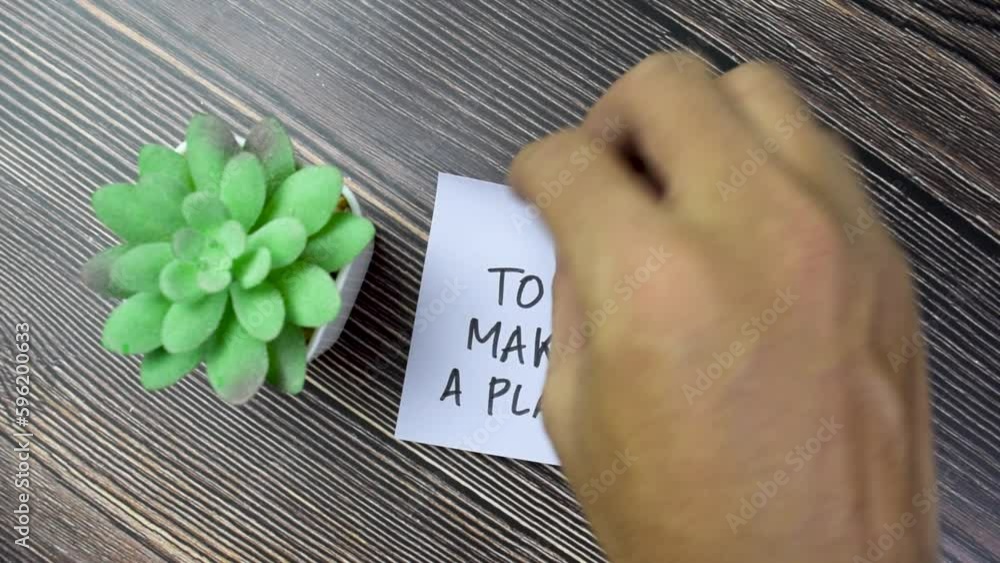 Poster concept of to make a plan! write on sticky notes isolated on wooden table.