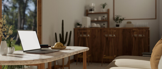 Laptop white screen mockup on a marble table in cozy minimal living room