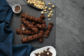 Tasty chocolate bars with nuts on black table, flat lay. Space for text