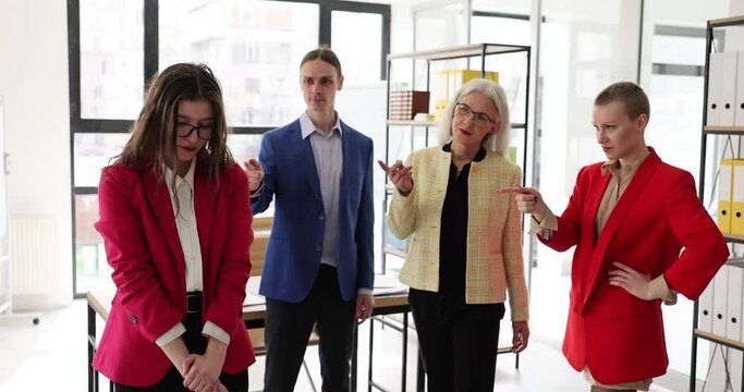 Frustrated tired female employee feels stressed, suffers from bad attitude and discrimination of colleagues. Groups of people accusing an employee of an obvious complaint of incompetence