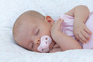 A newborn baby calmed and asleep thanks to his pacifier