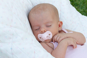 an adorable newborn baby sleep calming with pacifier