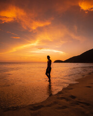 person running on the beach at sunset