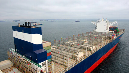 Aerial view of empty ultra large container ship at anchor near port Callao, Lima, Peru awaiting for...