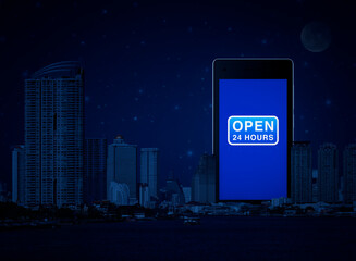 Open 24 hours icon on modern smart mobile phone screen over office city tower, river and fantasy night sky, Business full time service online concept