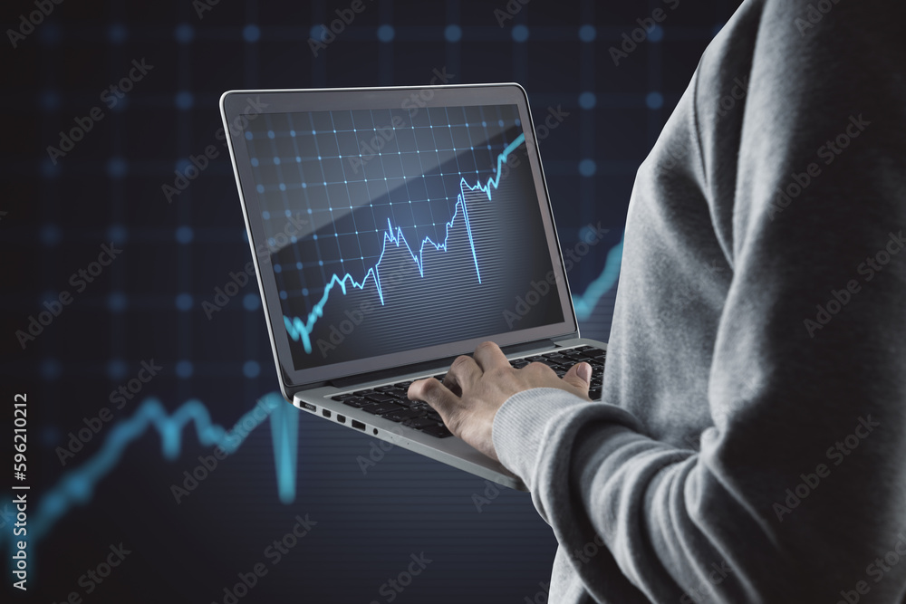 Poster Close up of hands using laptop computer with growing blue financial forex chart on dark grid background. Stock, economy, market and trade concept.