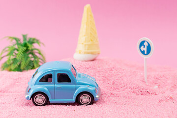 A toy car on pink sand