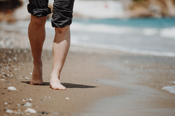 Vacation concept. Close up of female legs walking by the beach