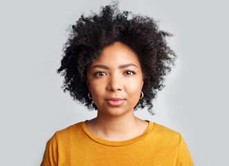 Serious, woman and portrait in studio, white background and confident on backdrop. Face of young female model with curly hair, afro and cool attitude in casual fashion, style or gen z of South Africa