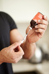 Man, filling a syringe or liquid injection of testosterone and bottle, steroids and closeup of...