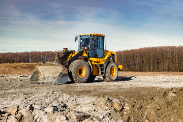 Powerful front wheel loader or bulldozer working on a quarry or construction site. earthworks in construction. Powerful modern equipment for earthworks.