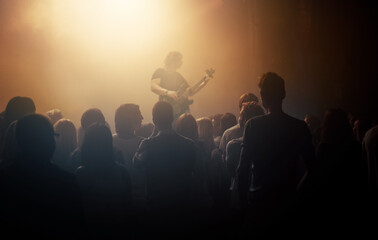 Dark crowd, musician and people at a concert for a guitar performance, music festival and band. Event, show and an audience enjoying live night entertainment, performer or an artist at a club