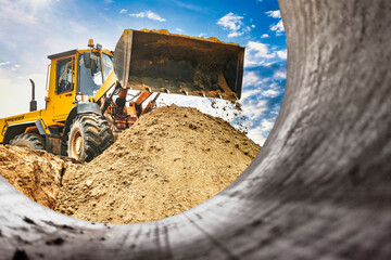 Powerful wheel loader or bulldozer working on a quarry or construction site. Close-up of...
