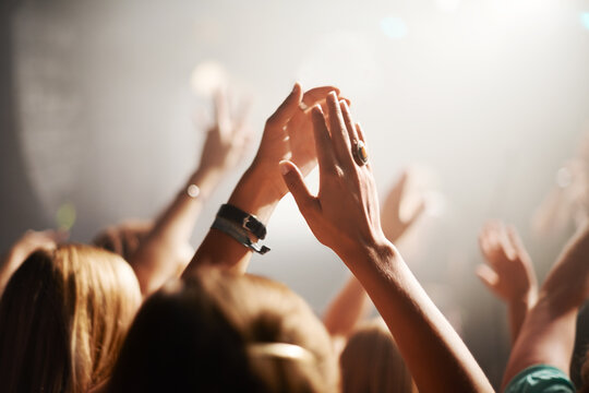 Clapping crowd, party and people at a concert for celebration, performance and watching a band. Energy, audience support and fans applause at a music festival, club or dancing rave show at night