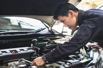 Auto mechanic working in garage, Technician man working in auto service, Mechanic repairman with a wrench repairing a car engine, Car repair, and maintenance