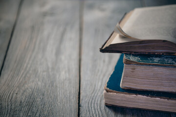 a stack of old books on a wooden desk, free space for text